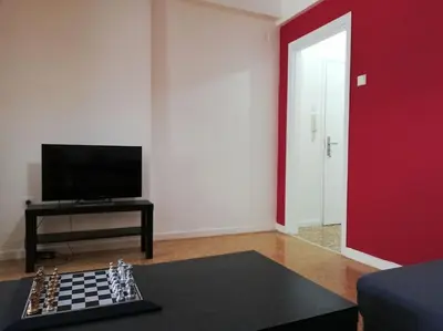 a living room with a chessboard on a table and a red wall at ArtHouse near the sea and the city center in Athens