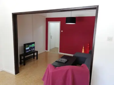 a living room with a couch and a red wall at ArtHouse near the sea and the city center in Athens