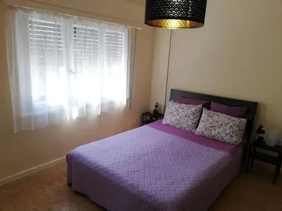 a bedroom with a purple bed with a window at ArtHouse near the sea and the city center in Athens