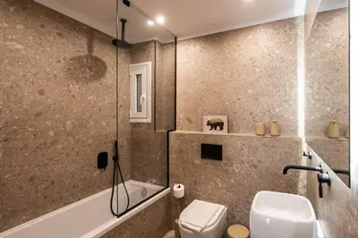 a bathroom with a tub and a toilet and a sink at 3BR Petralona Escape in Athens