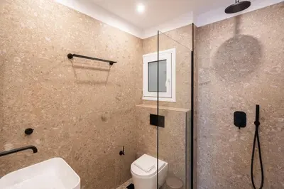 a bathroom with a shower and a toilet and a sink at 3BR Petralona Escape in Athens