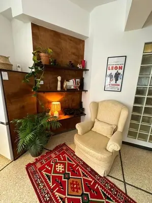 a living room with a chair and a rug at Epicurus Loft in Athens