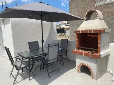 a table and chairs with an umbrella on a patio at Nikea apartment near Pireus port and metro st III in Piraeus
