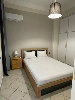 a bedroom with a bed and a night stand with a lamp at Nikea apartment near Pireus port and metro st III in Piraeus