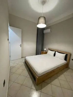 a bedroom with a large bed and a light at Nikea apartment near Pireus port and metro st III in Piraeus