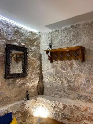 a stone wall with a guitar and a mirror at Akropole 700 m Koukaki Merkez in Athens