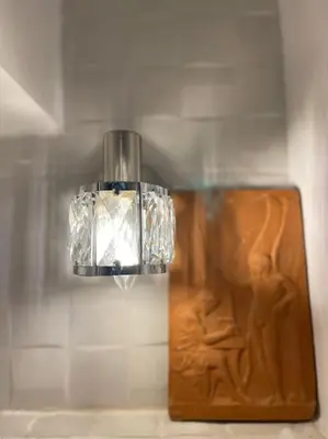 a light hanging from a wall next to a wooden board at Akropole 700 m Koukaki Merkez in Athens