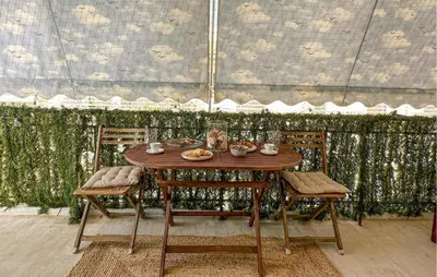 a wooden table with two chairs and food on it at Nice Apartment In Anavissos With Wifi in Anavissos