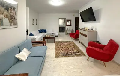 a living room with a blue couch and red chairs at Nice Apartment In Anavissos With Wifi in Anavissos