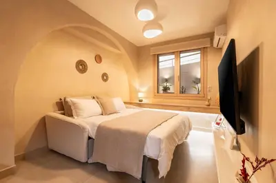 a bedroom with a bed and a flat screen tv at Gaia Nest in Piraeus