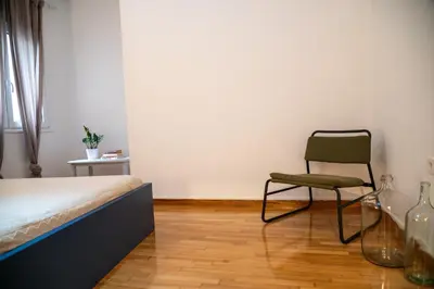 a bedroom with a bed and a chair in it at Acropolis central and comfortable apartment in Athens