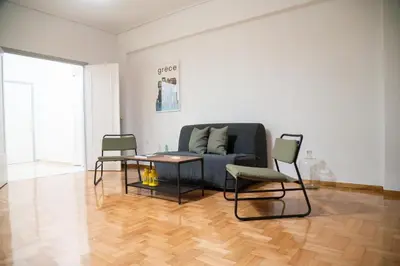 a living room with a couch and a table and chairs at Acropolis central and comfortable apartment in Athens