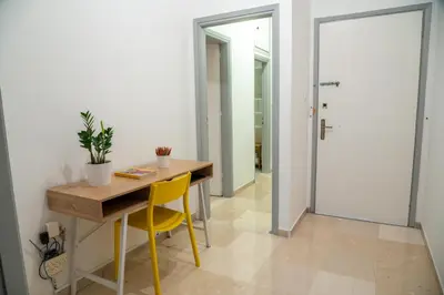 a room with a wooden table and yellow chairs at Acropolis central and comfortable apartment in Athens