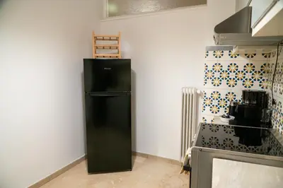 a black refrigerator in the corner of a kitchen at Acropolis central and comfortable apartment in Athens
