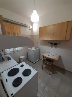 a kitchen with a stove and a table in it at Φιλόξενο studio στο Γαλάτσι in Athens