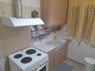 a small kitchen with a stove and a sink at Φιλόξενο studio στο Γαλάτσι in Athens