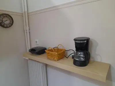 a shelf with a coffee maker and a basket on it at Φιλόξενο studio στο Γαλάτσι in Athens