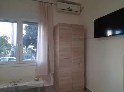 a living room with a dresser and a window at Φιλόξενο studio στο Γαλάτσι in Athens