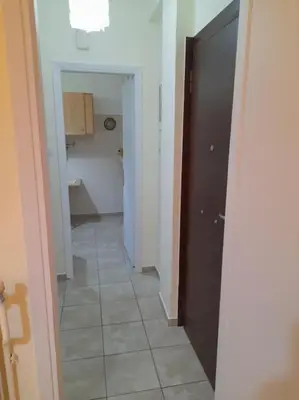 a hallway with a door and a tile floor at Φιλόξενο studio στο Γαλάτσι in Athens