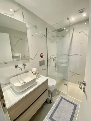 a white bathroom with a sink and a shower at ATHENIAN Vibes in Athens
