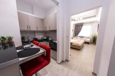 a kitchen and living room with red chairs and a table at Athens City Studio in Athens
