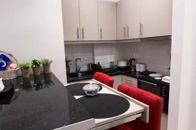 a kitchen with white cabinets and a black counter top at Athens City Studio in Athens