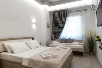 a bedroom with two beds and a window at Athens City Studio in Athens