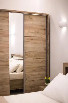 a bedroom with a large wooden closet with a mirror at Athens City Studio in Athens