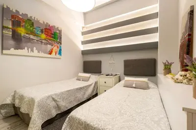 a bedroom with two beds and a painting on the wall at Diamond apartment in Athens