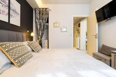 a bedroom with a large white bed and a television at Diamond apartment in Athens