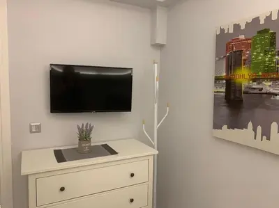 a room with a tv on a wall with a dresser at Diamond apartment in Athens