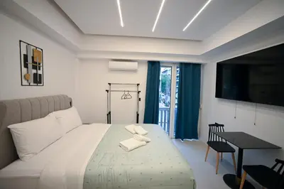a bedroom with a bed and a table and a television at Erato suite by Zeussuites in Athens