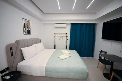 a bedroom with a bed and a table and a television at Erato suite by Zeussuites in Athens