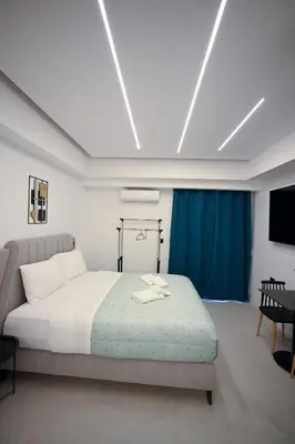 a bedroom with a bed and a blue curtain at Erato suite by Zeussuites in Athens