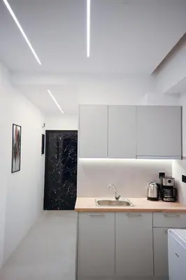 a kitchen with white cabinets and a sink at Erato suite by Zeussuites in Athens