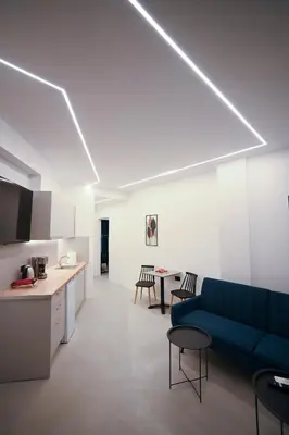 a living room with a blue couch and a table at Apollon Family Apartment by zeussuites in Athens