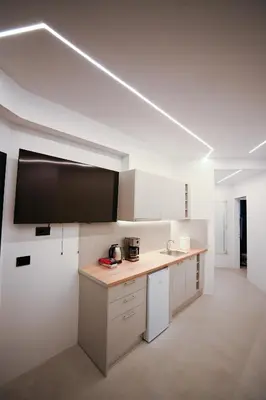 a kitchen with a counter and a flat screen tv at Apollon Family Apartment by zeussuites in Athens