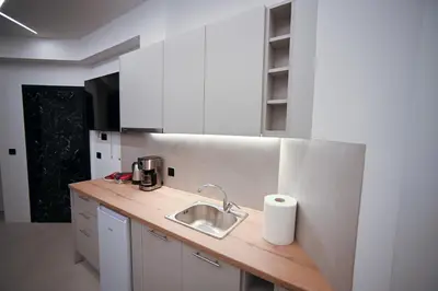a white kitchen with a sink and a counter at Apollon Family Apartment by zeussuites in Athens
