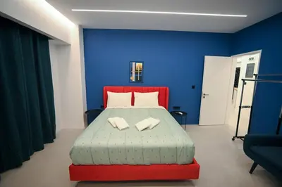 a blue bedroom with a bed with two pillows at Apollon Family Apartment by zeussuites in Athens