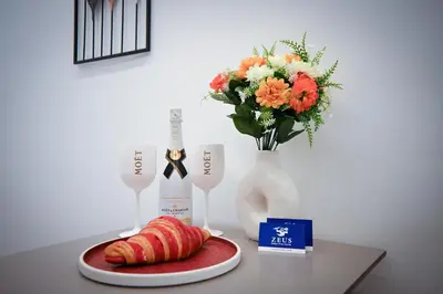 a table with a vase with flowers and a plate of food at Apollon Family Apartment by zeussuites in Athens