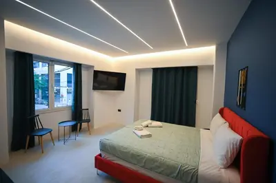 a bedroom with a bed with a red couch at Apollon Family Apartment by zeussuites in Athens