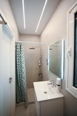 a bathroom with a sink and a shower with a mirror at Museum Family Apartment by Zeussuites in Athens