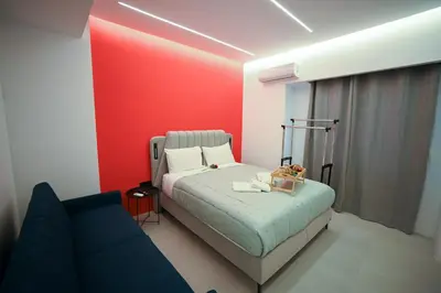 a bedroom with a bed and a red wall at Museum Family Apartment by Zeussuites in Athens