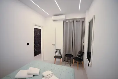 a white room with a bed and two chairs at Museum Family Apartment by Zeussuites in Athens