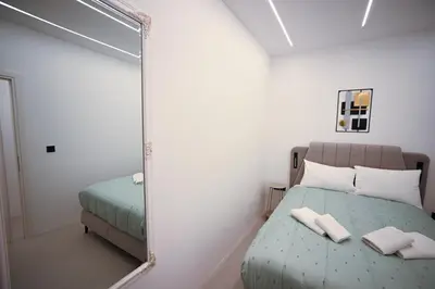 a bedroom with a mirror next to a bed at Museum Family Apartment by Zeussuites in Athens