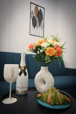 a table with a vase with flowers and a plate of food at Museum Family Apartment by Zeussuites in Athens