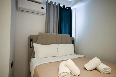 a bedroom with a bed with two pillows and a window at Aris Suite by Zeussuites in Athens
