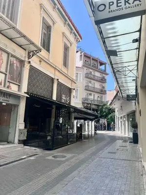 an empty street with shops and buildings on it at Aris Suite by Zeussuites in Athens