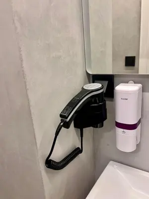 a phone hanging on a wall next to a toilet at Aris Suite by Zeussuites in Athens