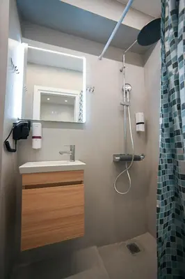 a bathroom with a sink and a mirror and a shower at Aris Suite by Zeussuites in Athens
